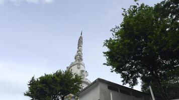 Sri Lanka, Kandy - July 29, 2023. White Tower in Sri Lanka. Action. View from below at foot of white tower of ambuluvava. Swirling white tower with green trees in Sri Lanka photo