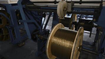 Industrial Machine for winding copper wire on coils. Creative. Automated production of metallurgical plant with swirling copper wires. Winding of copper wire on bobbins of industrial machine photo