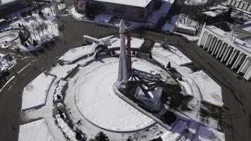 Top view of rocket monument in winter. Creative. Rocket monument on city square on sunny winter day. Large-scale monument to space flight with rocket on square photo