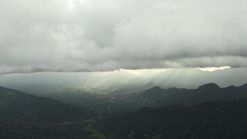 Beautiful view of mountain green valley with clouds and sunlight. Action. Picturesque landscape of green mountains and low clouds with sun breaking through. Sun's rays on horizon in green mountain photo