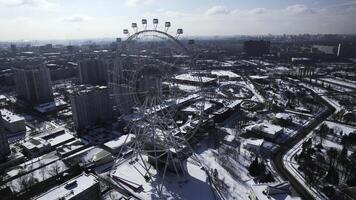 Top view of big Ferris wheel in winter. Creative. Beautiful urban landscape with Ferris wheel in city center in winter. Ferris wheel in center of big city on sunny winter day photo