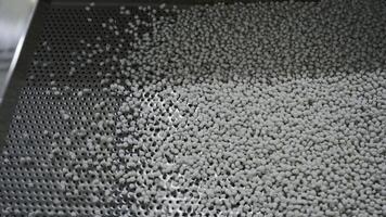 Cleaning of polymer granules. Creative. Mesh for cleaning white polymer granules from debris and foreign particles. Chemical workshop for plastic processing and cleaning photo