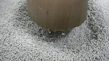 de cerca de polímero gránulos en producción. creativo. proceso de extrusión y el secado de el plastico gránulos pila de blanco el plastico pellets en industrial taller foto