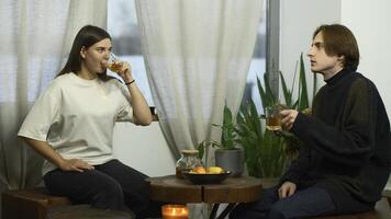 Students communicate and drink tea in cafe. Media. Young man and woman are drinking tea and talking in cafe. Cheerful conversation between young couple of students in cozy cafe photo