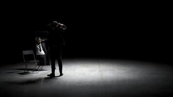 Man combs his hair in front of mirror on stage. Stock footage. Man in suit combs hair in front of mirror. Stage production with one man in suit and mirror photo