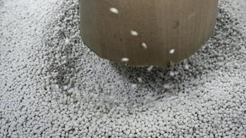 Close-up of polymer granules in production. Creative. Process of extrusion and drying of plastic granules. Pile of white plastic pellets in industrial workshop photo