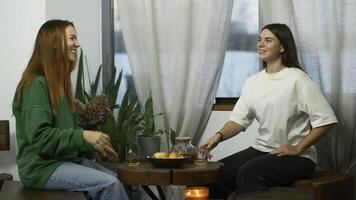 Young women drink tea and have fun chatting in cafe. Media. Young students are having fun talking in cozy college cafe. Women drink tea and laugh in cafe photo