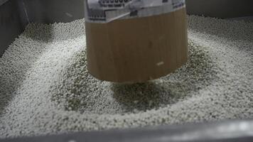 Close-up of polymer granules in production. Creative. Process of extrusion and drying of plastic granules. Pile of white plastic pellets in industrial workshop photo