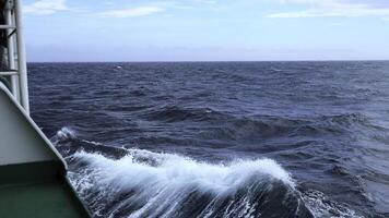 Waves from floating sea vessel. Clip. Beautiful moving waves from floating ship at sea. Beautiful sea horizon with moving waves from ship photo