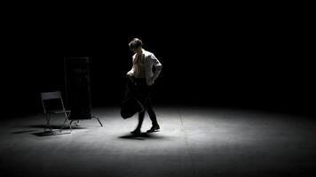 Man in suit alone on theater stage. Stock footage. Single attractive man in suit is playing on stage of theater. Man in suit with mirror is alone on dark theatrical stage photo