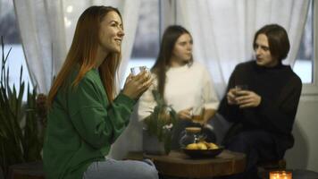 Students talk and relax in cozy cafe. Media. Beautiful young woman is drinking tea on background of talking couple. Students relax and drink tea in college cafe photo