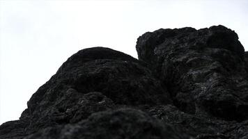 Giant rocks on cloudy sky background. Clip. Close up of grey stone texture. photo