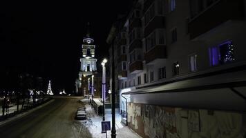 Aerial view of the illuminated church and residential buildings. Clip. Beautiful city at night. photo