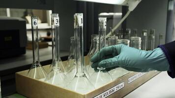 Medical research laboratory equipment. Clip. A scientist hands in gloves taking a flask, concept of research in chemistry, biochemistry and experiments. photo