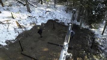 Work on a construction site during winter. Clip. Industrial background outdoors in winter forest. photo