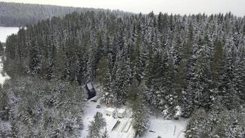 aéreo de magia Nevado invierno mundo maravilloso con un pequeño glamping sin construir casa entre arboles acortar. invierno temporada en Nevado montaña bosque. foto