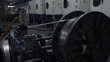 Metal long narrow sheets wraping on a bobbin. Creative. Large spool in a factory workshop, industrial background. photo