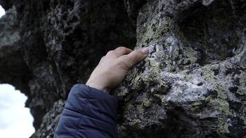 Nature, touch and rock with woman hand feeling texture, surface or terrain of mountain. Clip. Travel, trekking and ecology with female palm on stone. photo