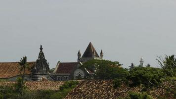 Roofs of buildings and grey sky. Action. Red roofs and green trees on a summer day. photo