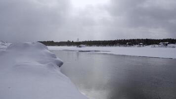 invierno paisaje de frío amplio río. acortar. congelado paisaje con bosque y doblar río. foto