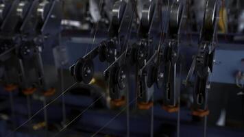 Close up of many small steel wire coils at the factory. Creative. Industrial background with thin wires stretching from the spinning spools. photo