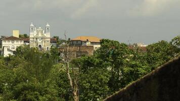 Roofs of buildings and grey sky. Action. Red roofs and green trees on a summer day. photo