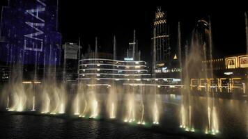 Dubai - UAE - October 5, 2023. Burj Khalifa at Dubai Mall and fountain show in UAE at night. Action. Famous landmark of Dubai city center. photo