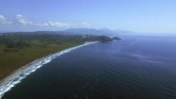 Cinematic drone shot of the north atlantic ocean coastline. Clip. Azure sea and meadows with blue sky above. photo