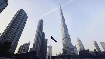 burj califa a dubai centro comercial en eau, famoso punto de referencia. acción. bajo ángulo ver de un rascacielos y palma arboles foto