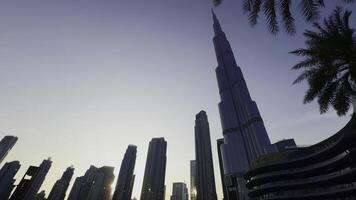 Low angle view of Burj Khalifa with blue sky behind. Action. Modern glass facade skyscraper in the city center. photo