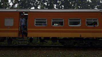 Side view of a train carrying tourists on a summer day. Action. Old train and green vegetation round, concept of public transport in the countryside. photo