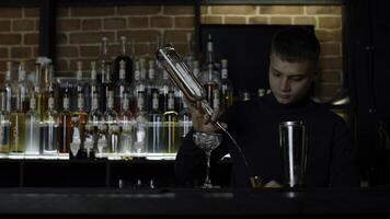 frio profesional caucásico barman haciendo un cóctel. medios de comunicación. auténtico barman haciendo alcohol bebidas en moderno bar. foto