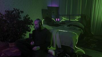 Man using smartphone and listening to music at home. Media. Cozy and messy room of a hipster guy. photo