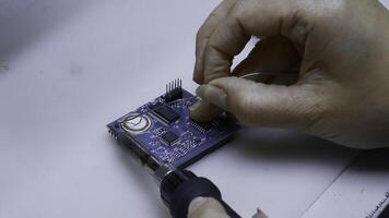 joven hombre reparando computadora componentes en Servicio centro. creativo. cerca arriba de soldadura el chip. foto