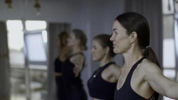 Group of sportive people during a gym training with a coach. Media. Girls group of athletes swinging hands before starting a workout yoga session. photo