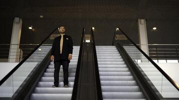 Young man moving down on escalator in a big business center. Media. Modern escalator stairs. photo