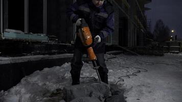 Man drills holes in a concrete block. Clip. Industrial background of a builder at the construction site. photo