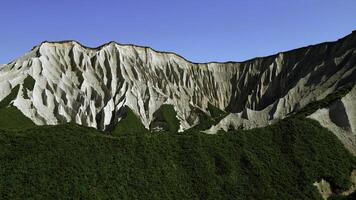 Beautiful aerial of the white cliffs on the south coast of England. Clip. Green summer forested hills and blue sky. photo