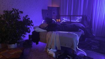 Man listening to music, using headphones in bedroom at night. Media. Man lying on his bed and enjoying music. photo