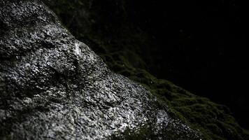 cubierto de musgo montaña Pendiente con gotas de agua que cae abajo. creativo. entrar dentro un oscuro grande cueva. foto