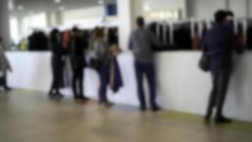 personas tomando ropa desde el armario. medios de comunicación. borroso multitud de visitantes a guardarropa a el centro comercial. foto