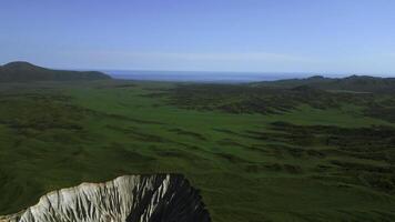 Aerial view of summer green valley and stony cleft. Clip. Flying above stunning summer hilly region. photo