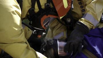 Firefighters giving oxygen to woman victim of fire. Clip. Close up of first aid after disaster. photo
