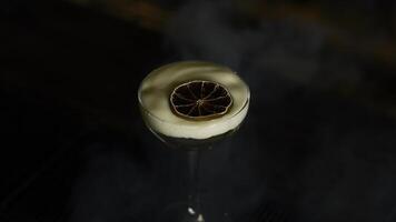 Close up of beautiful cocktail with thick foam and dried orange slice. Media. Beverage on bar counter background. photo