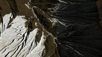 Aerial of wide gorge with rocky cliffs from both sides of small canyon. Clip. Stone slopes and yellow autumn grass. photo