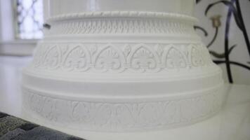 Close up of white beautiful pillar with carved pattern. Scene. Interior details of a white mosque. photo