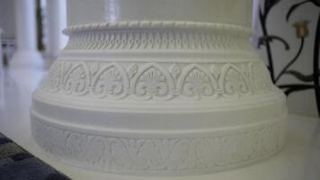 Close up of white beautiful pillar with carved pattern. Scene. Interior details of a white mosque. photo