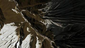 Aerial top view of the mysterious mountain rocks. Clip. White stone layers and brown ground. photo
