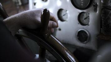 The ship's captain turns the wheel of the ship. Clip. Close up of man hand turning wooden steering wheel. photo