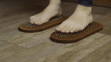 Close up view f woman standing on nails. Media. Practice of standing on nails, concept of feelings breakthrough. photo